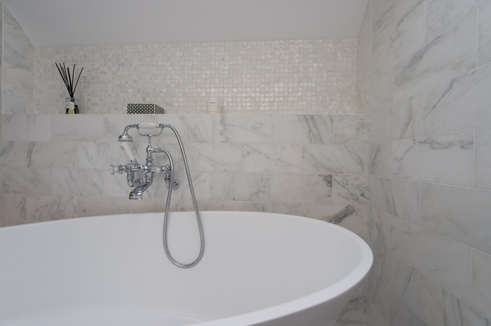 This is an example of a contemporary kids bathroom in West Midlands with white tile, marble and white walls.