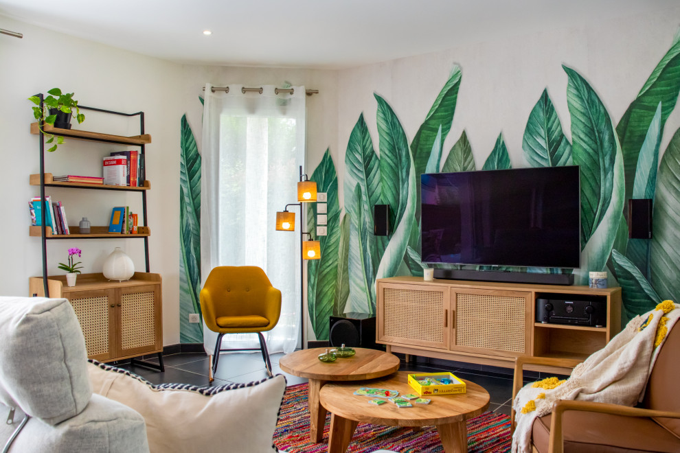 Idee per un soggiorno tropicale di medie dimensioni e aperto con libreria, pareti verdi, pavimento con piastrelle in ceramica, stufa a legna, TV a parete, pavimento grigio e carta da parati