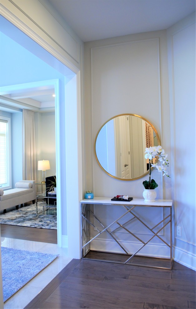 Inspiration for a large transitional medium tone wood floor and brown floor foyer remodel in Toronto with gray walls and a medium wood front door