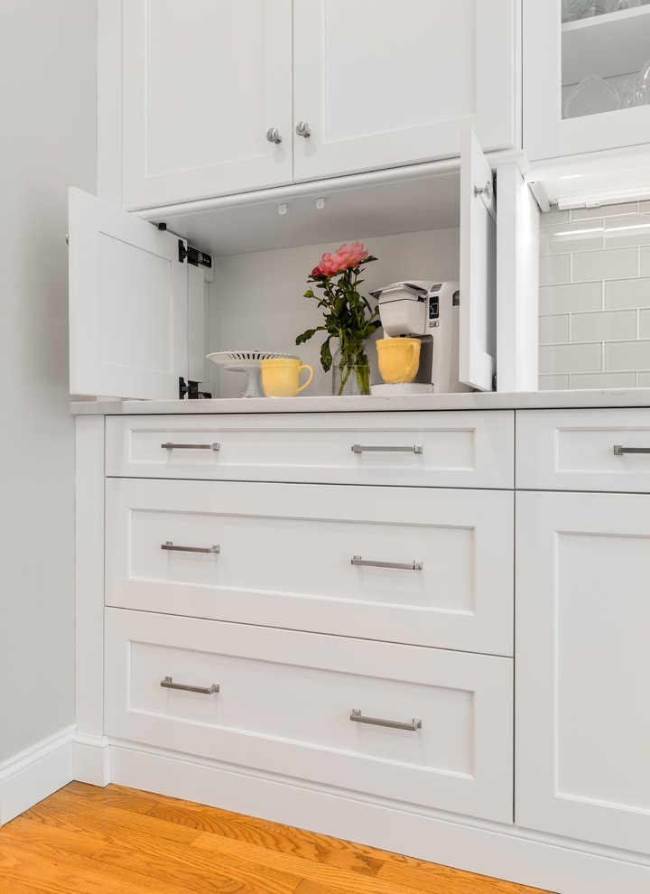 Eat-in kitchen - transitional u-shaped eat-in kitchen idea in Providence with an undermount sink, white cabinets, quartzite countertops, glass tile backsplash, stainless steel appliances and an island