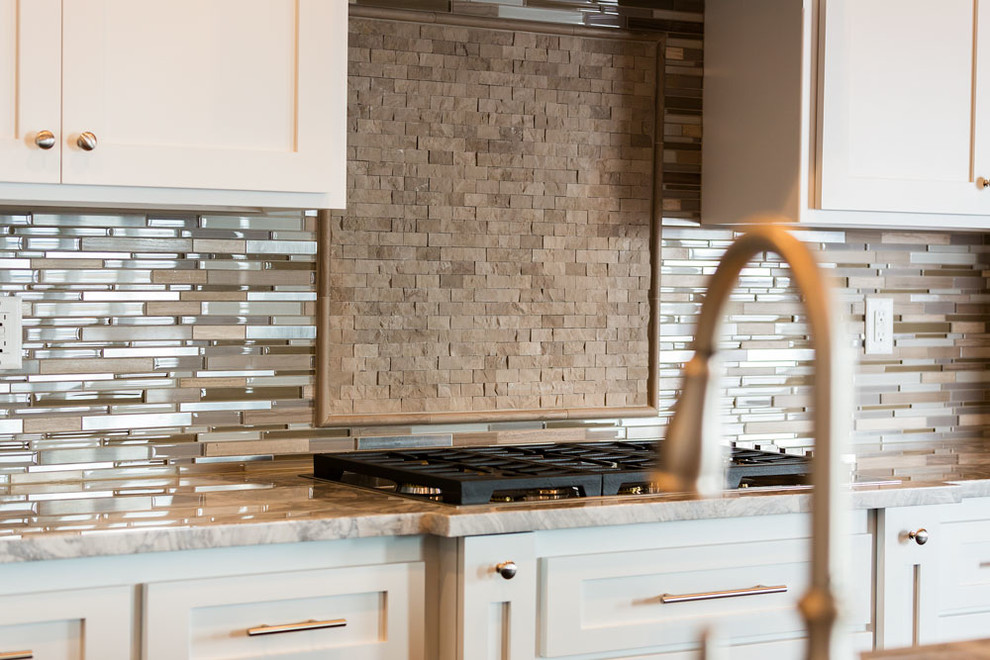 Kitchen - large transitional kitchen idea with white cabinets, granite countertops, metallic backsplash, glass tile backsplash, recessed-panel cabinets and an island