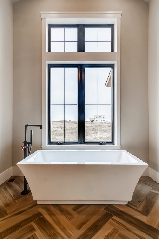 Пример оригинального дизайна: большая главная ванная комната в стиле кантри с фасадами в стиле шейкер, белыми фасадами, отдельно стоящей ванной, душем без бортиков, белой плиткой, керамогранитной плиткой, серыми стенами, полом из керамогранита, врезной раковиной, столешницей из кварцита, бежевым полом, душем с распашными дверями, серой столешницей, сиденьем для душа, тумбой под две раковины, встроенной тумбой и балками на потолке