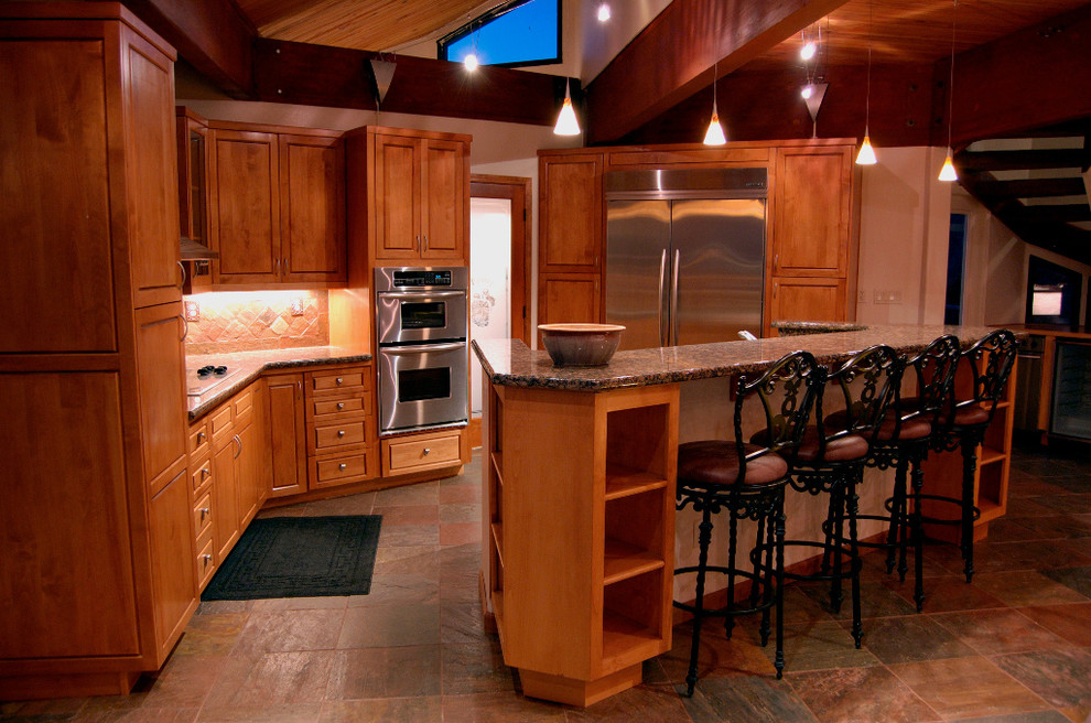Enclosed kitchen - mid-sized rustic l-shaped slate floor and multicolored floor enclosed kitchen idea with raised-panel cabinets, medium tone wood cabinets, granite countertops, stone tile backsplash, stainless steel appliances and an island
