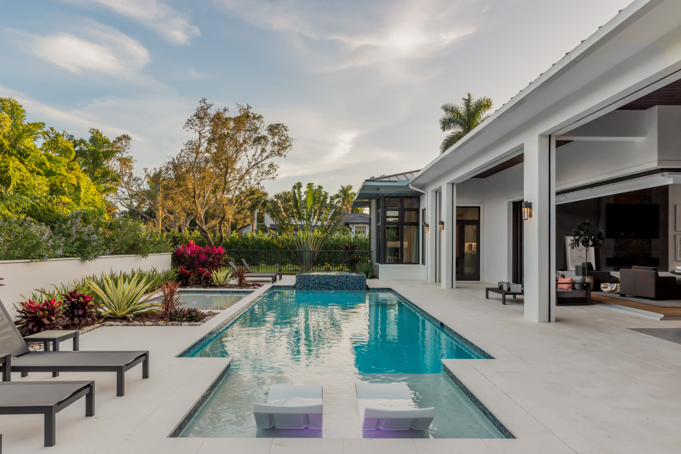 Design ideas for a contemporary rectangular pool in Miami with a hot tub and tile.