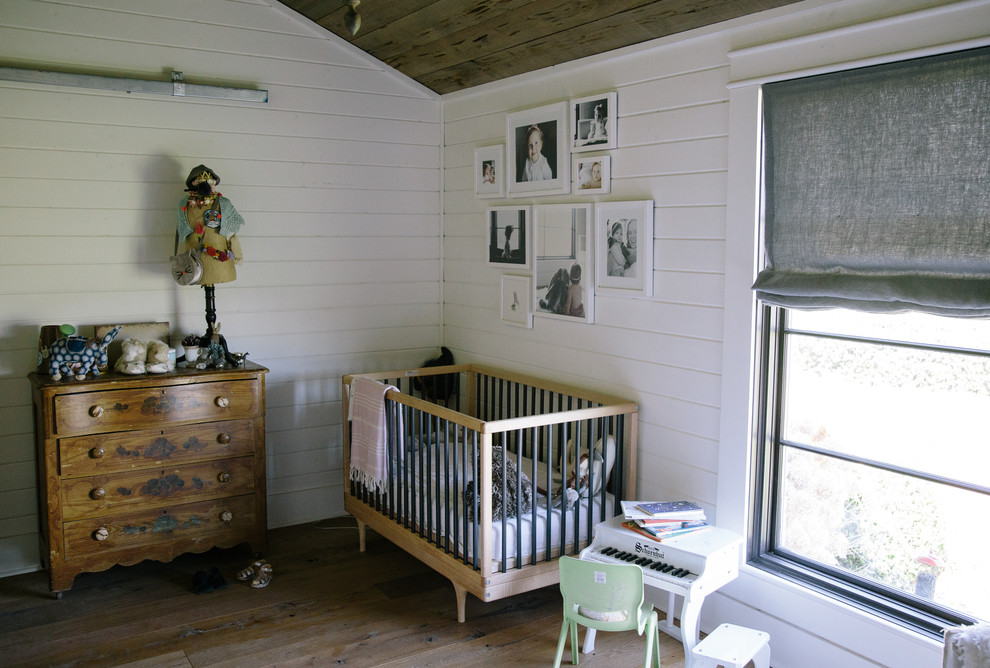 Inspiration for a country nursery for girls in Nashville with white walls and medium hardwood floors.