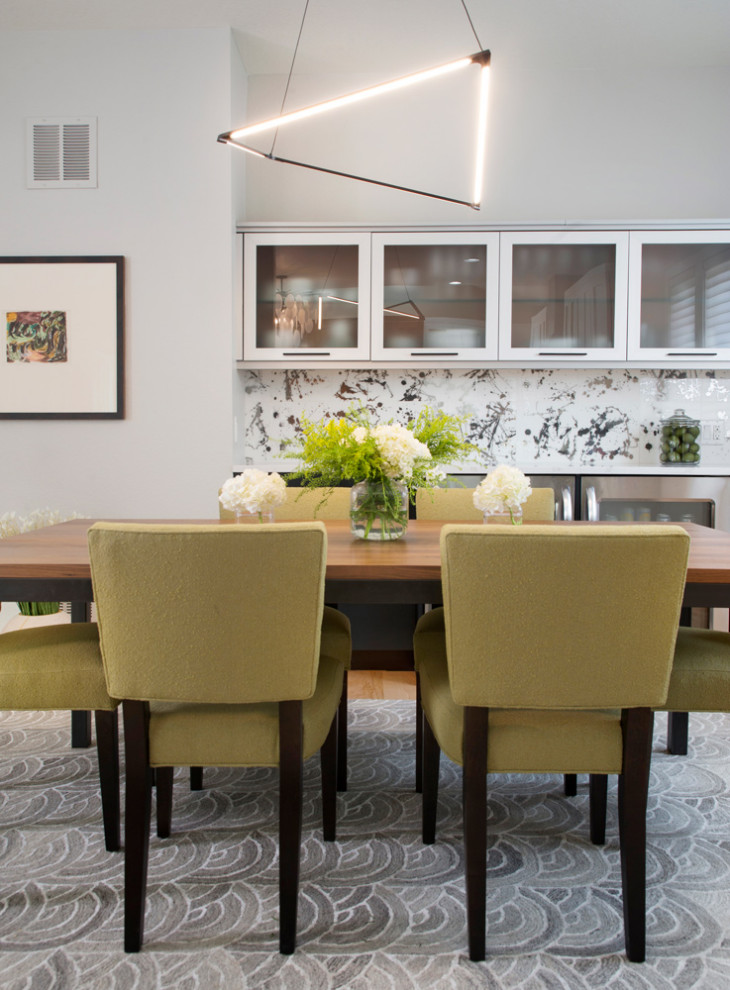 Immagine di una sala da pranzo aperta verso la cucina contemporanea di medie dimensioni con pareti beige, pavimento in legno massello medio e nessun camino