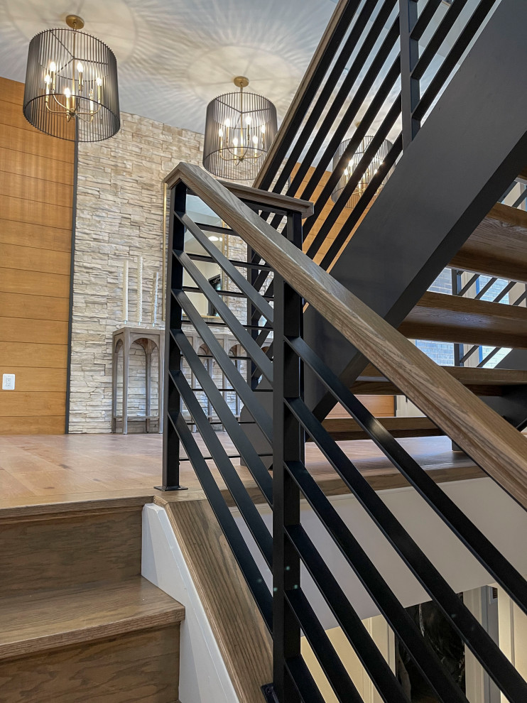 Large contemporary wood straight staircase in DC Metro with mixed railing and panelled walls.