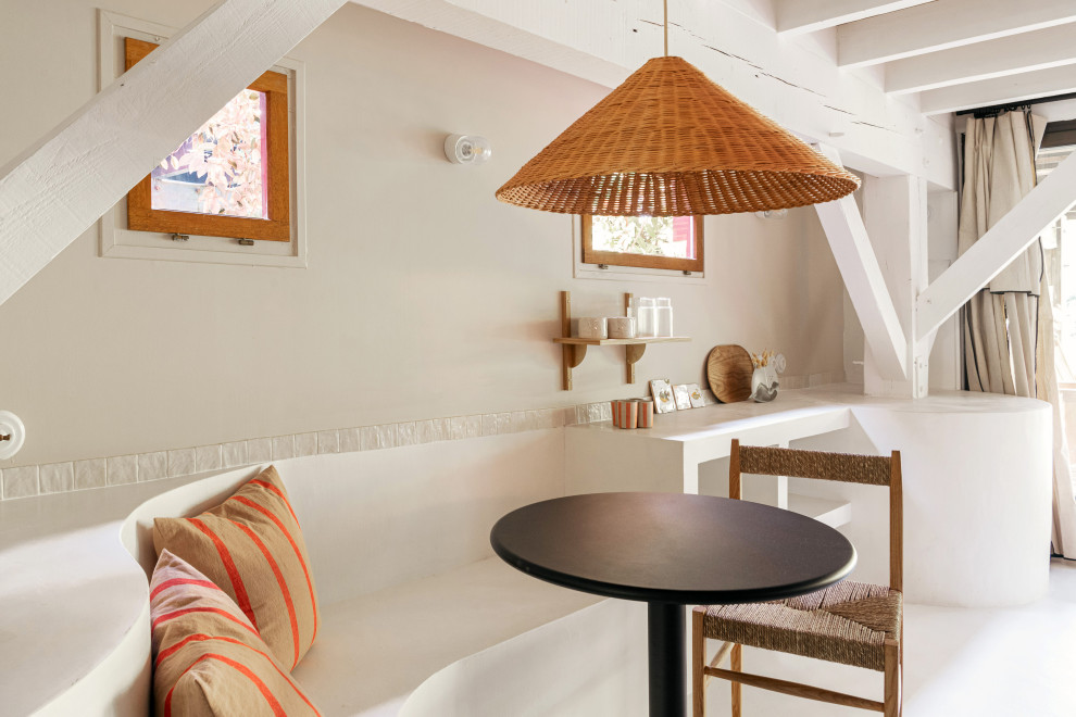Cette image montre un salon méditerranéen ouvert avec un mur beige, sol en béton ciré, un sol blanc, un plafond en bois et du papier peint.