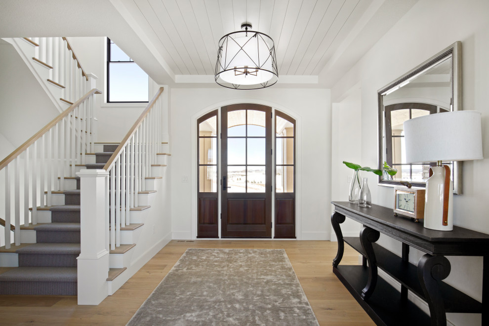 Aménagement d'un hall d'entrée classique avec un mur blanc, parquet clair, une porte en bois foncé et un plafond en lambris de bois.