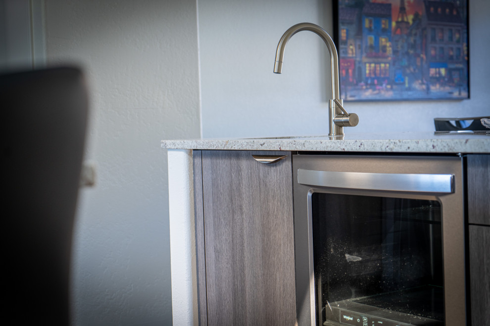 Trendy kitchen photo in Phoenix with flat-panel cabinets, gray cabinets, stainless steel appliances and an island
