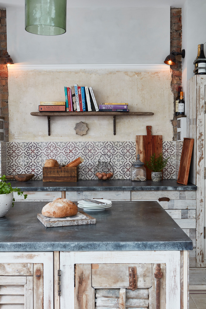 Inspiration for a mid-sized mediterranean single-wall open plan kitchen in London with an undermount sink, louvered cabinets, distressed cabinets, multi-coloured splashback, cement tile splashback, cement tiles and with island.