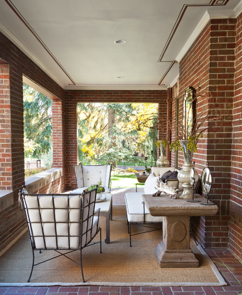 Photo of a traditional verandah in Denver with brick pavers and a roof extension.