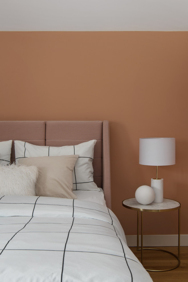 Пример оригинального дизайна: хозяйская спальня среднего размера на мансарде в современном стиле с оранжевыми стенами, паркетным полом среднего тона, бежевым полом и многоуровневым потолком