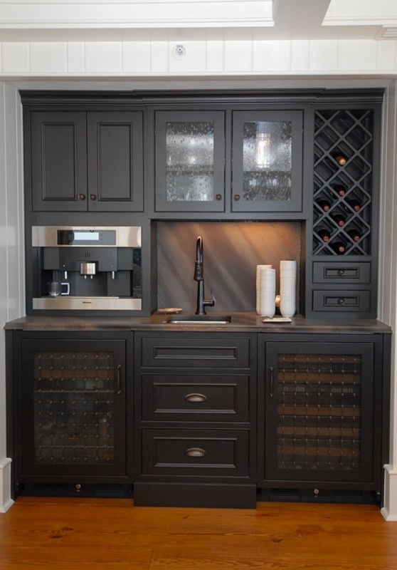 Small traditional single-wall wet bar in Orlando with an undermount sink, recessed-panel cabinets, black cabinets, laminate benchtops, multi-coloured splashback and medium hardwood floors.