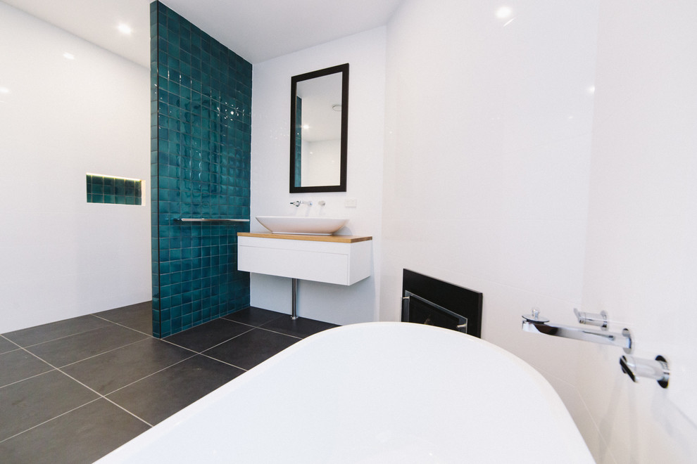 Photo of a mid-sized contemporary bathroom in Sydney with wood benchtops and white tile.