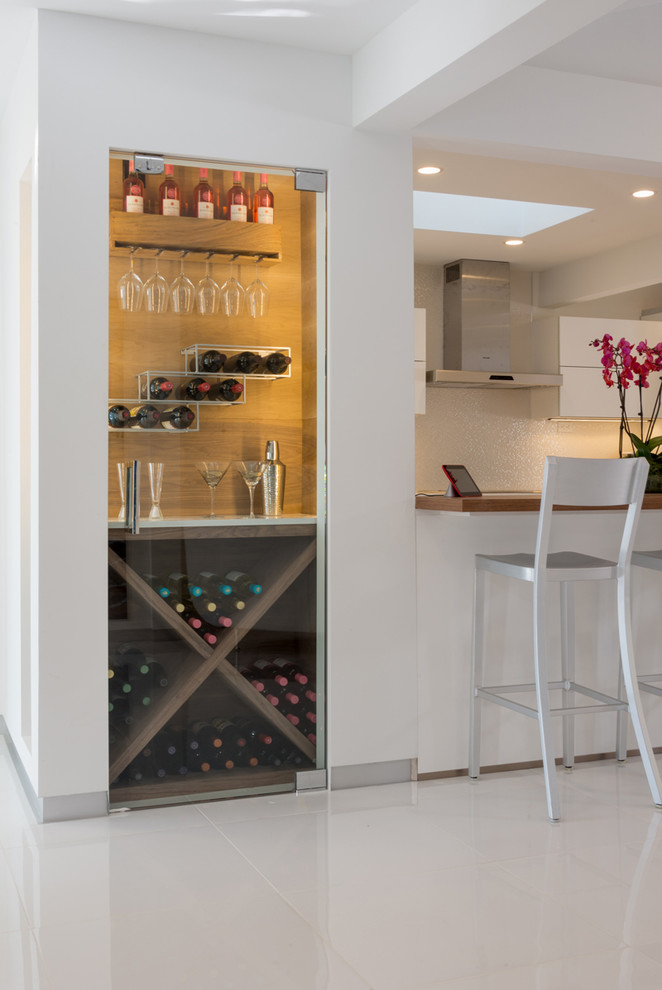 Photo of a small modern single-wall wet bar in Los Angeles with glass-front cabinets, quartzite benchtops and white floor.