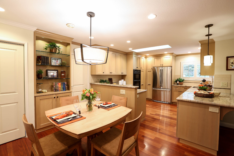 Example of a mid-sized transitional medium tone wood floor enclosed kitchen design in San Francisco with a double-bowl sink, shaker cabinets, light wood cabinets, granite countertops, beige backsplash, subway tile backsplash, stainless steel appliances and a peninsula