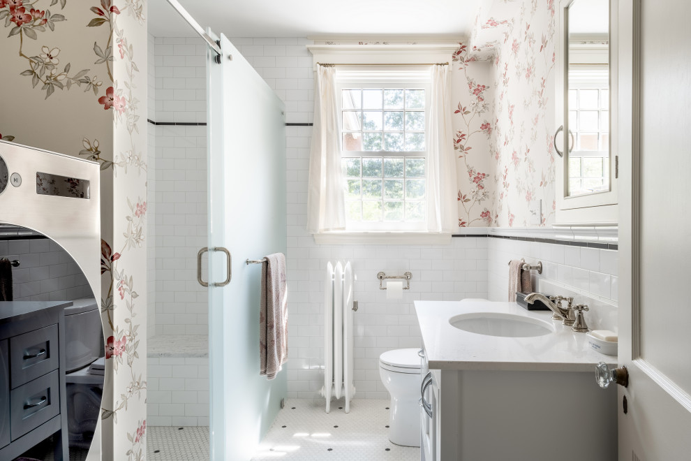 Bathroom - mid-sized traditional 3/4 black and white tile and ceramic tile ceramic tile, white floor, single-sink and wallpaper bathroom idea in Boston with shaker cabinets, white cabinets, a one-piece toilet, white walls, an integrated sink, quartz countertops, white countertops and a freestanding vanity