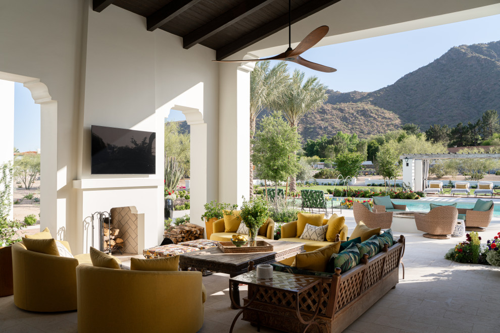 Photo of a mediterranean patio in Phoenix with with fireplace and a roof extension.