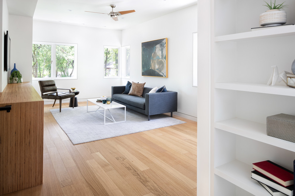 Large minimalist enclosed light wood floor and brown floor family room photo in Austin with white walls, no fireplace and no tv