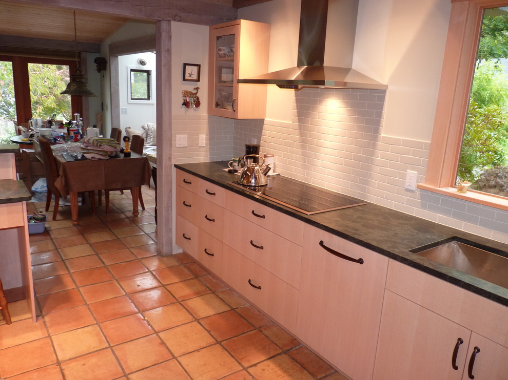 Eat-in kitchen - transitional galley eat-in kitchen idea in Seattle with an undermount sink, flat-panel cabinets, light wood cabinets, soapstone countertops, gray backsplash, porcelain backsplash and paneled appliances