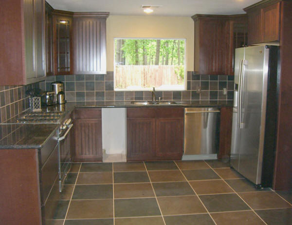Example of a large transitional u-shaped ceramic tile and brown floor eat-in kitchen design in Houston with a double-bowl sink, raised-panel cabinets, dark wood cabinets, granite countertops, brown backsplash, ceramic backsplash, stainless steel appliances and no island