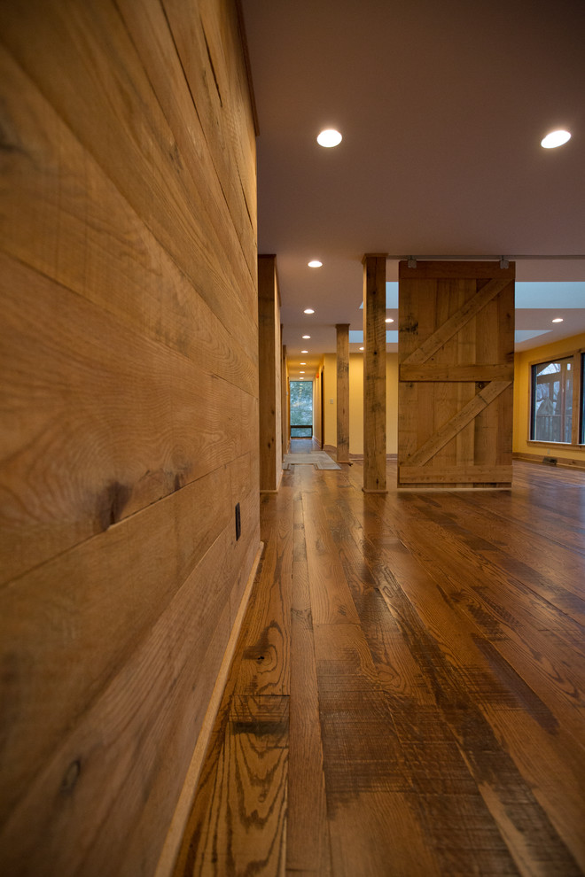 Inspiration for a large rustic dark wood floor hallway remodel with brown walls