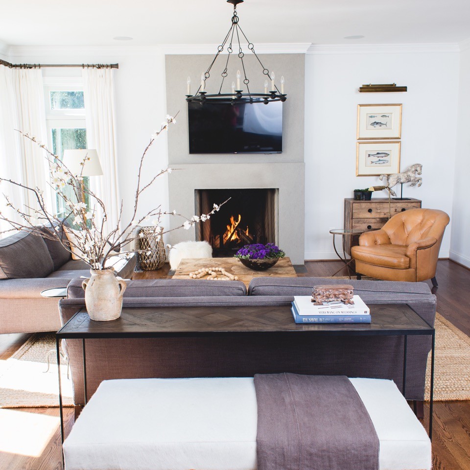Inspiration for an arts and crafts open concept living room in Los Angeles with white walls, medium hardwood floors, a standard fireplace, a concrete fireplace surround and a wall-mounted tv.