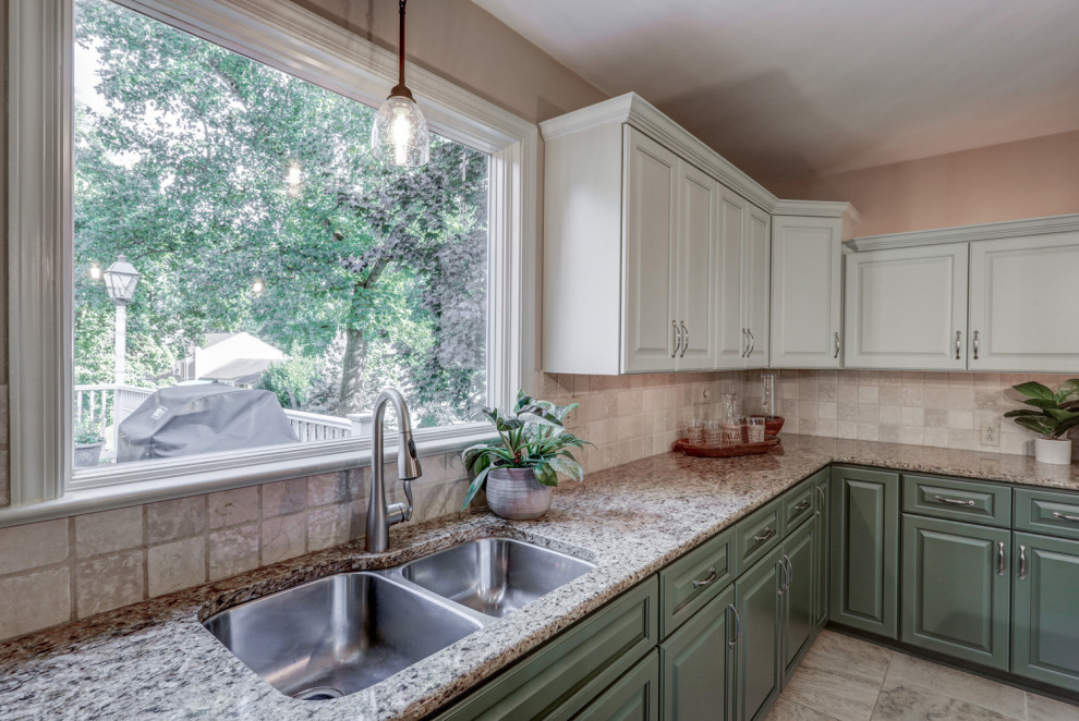 Inspiration for a mid-sized transitional l-shaped ceramic tile and beige floor eat-in kitchen remodel with a double-bowl sink, raised-panel cabinets, green cabinets, granite countertops, beige backsplash, ceramic backsplash, stainless steel appliances, an island and beige countertops