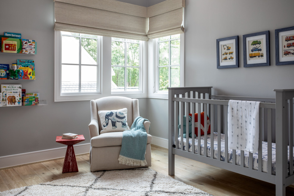 This is an example of a large transitional nursery for boys in Houston with grey walls, light hardwood floors and brown floor.