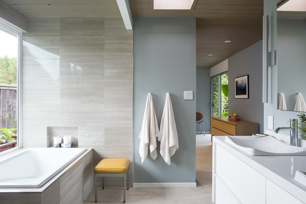 Contemporary bathroom in San Francisco with a vessel sink, a drop-in tub and blue walls.