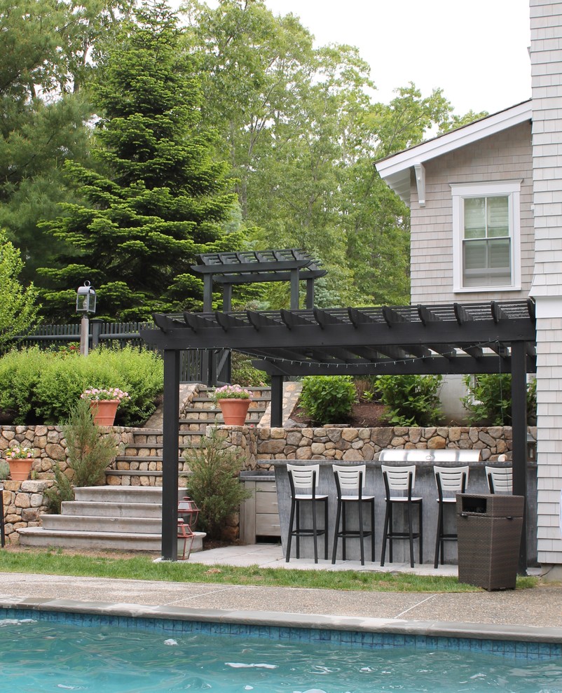 Large traditional backyard patio in Boston with an outdoor kitchen, a pergola and concrete pavers.