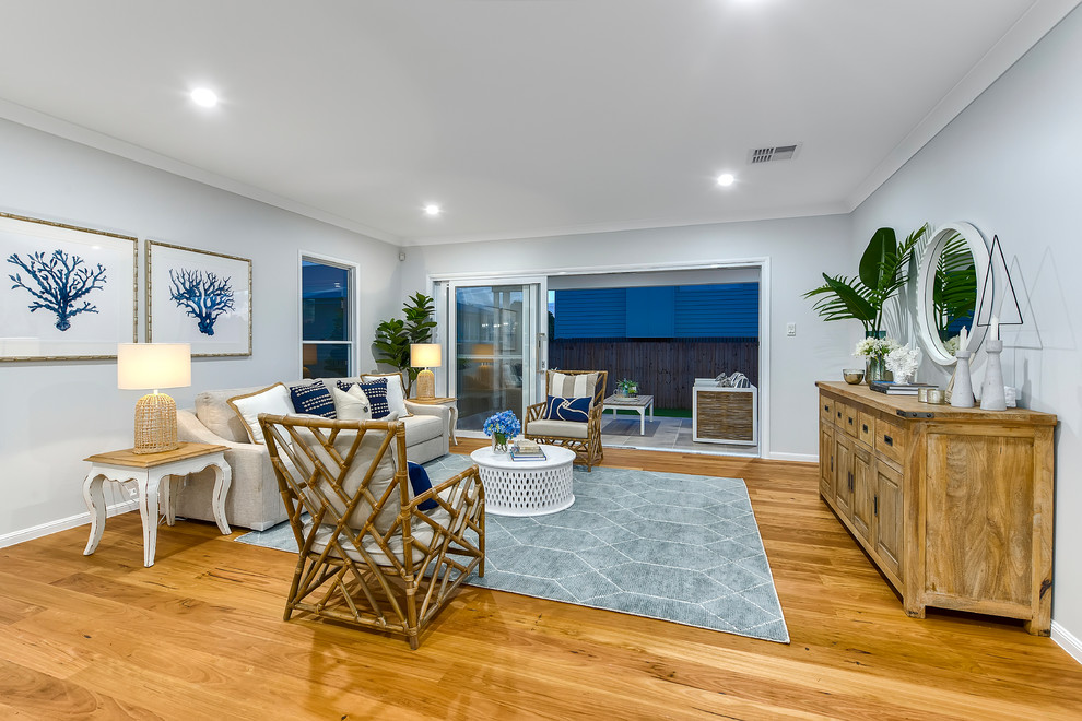 Photo of a beach style formal open concept living room in Brisbane with grey walls, medium hardwood floors, no tv and brown floor.
