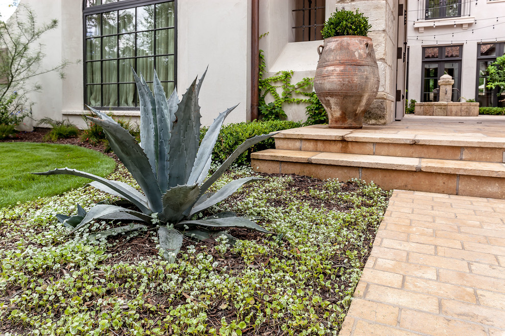 Inspiration for a large mediterranean front yard garden in Houston with a garden path and brick pavers.