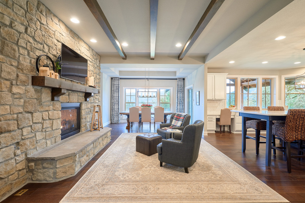 This is an example of a mid-sized transitional open concept family room in Portland with grey walls, dark hardwood floors, a two-sided fireplace, a stone fireplace surround, a wall-mounted tv and brown floor.