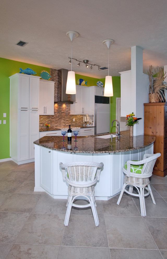 Mid-sized beach style galley eat-in kitchen in Tampa with an undermount sink, shaker cabinets, white cabinets, granite benchtops, brown splashback, white appliances and ceramic floors.