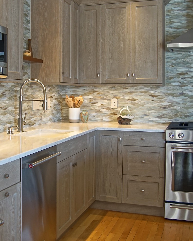 Inspiration for a mid-sized transitional l-shaped medium tone wood floor and beige floor eat-in kitchen remodel with an undermount sink, beaded inset cabinets, distressed cabinets, marble countertops, gray backsplash, ceramic backsplash, stainless steel appliances, an island and white countertops