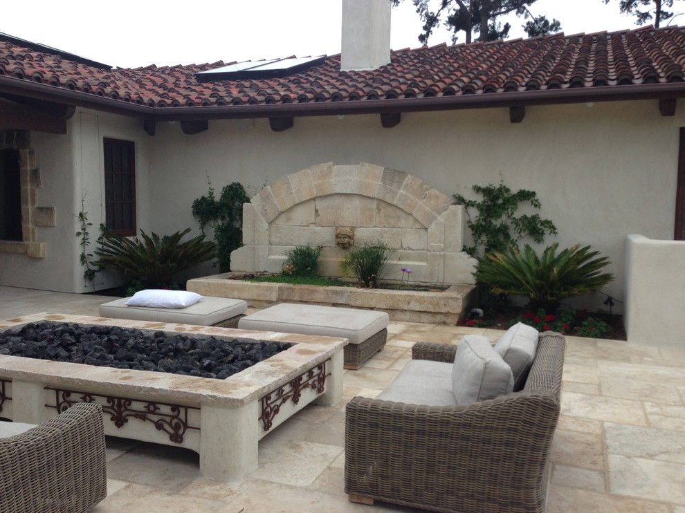 Large mediterranean courtyard patio in San Diego with a water feature, natural stone pavers and no cover.