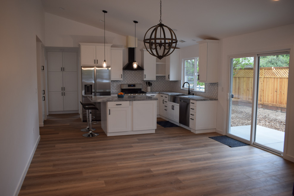 Immagine di una grande cucina country con pavimento in laminato, pavimento marrone e soffitto a volta