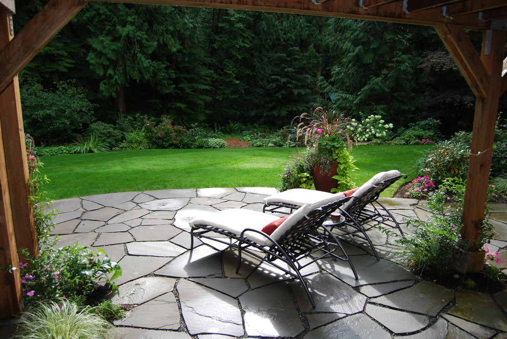 Inspiration for a large traditional backyard partial sun formal garden for summer in Seattle with natural stone pavers.