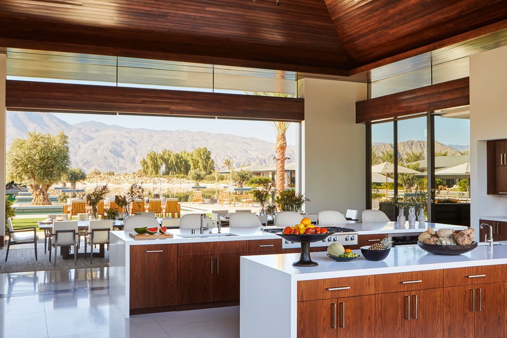 Example of a large minimalist white floor open concept kitchen design with an undermount sink, flat-panel cabinets, dark wood cabinets, quartz countertops, stainless steel appliances, two islands and white countertops
