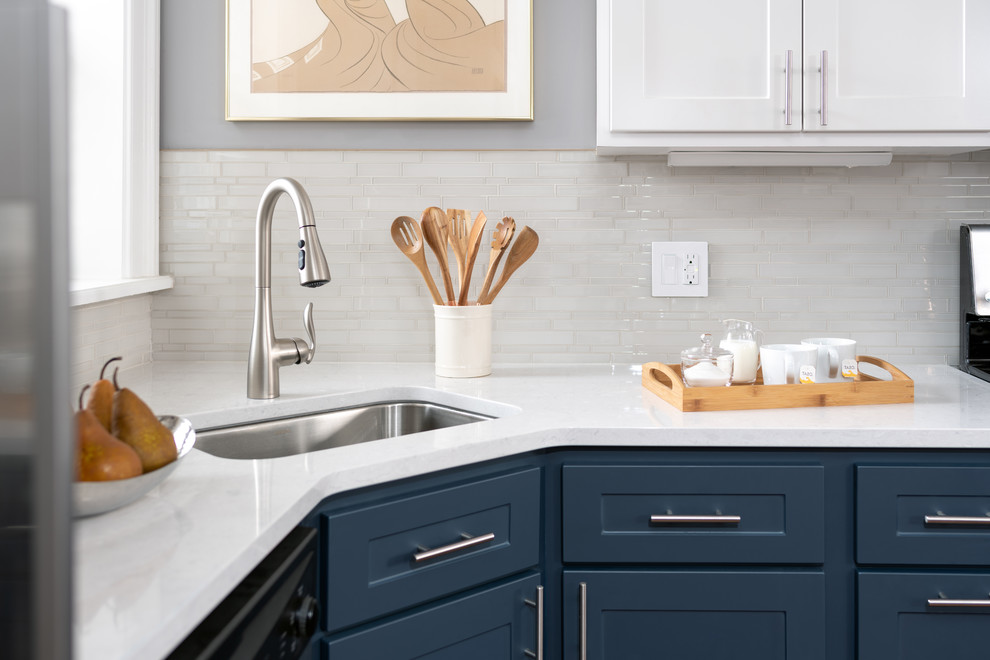 Inspiration for a mid-sized contemporary u-shaped eat-in kitchen in Philadelphia with a single-bowl sink, flat-panel cabinets, blue cabinets, quartzite benchtops, white splashback, ceramic splashback, stainless steel appliances, dark hardwood floors, brown floor and white benchtop.