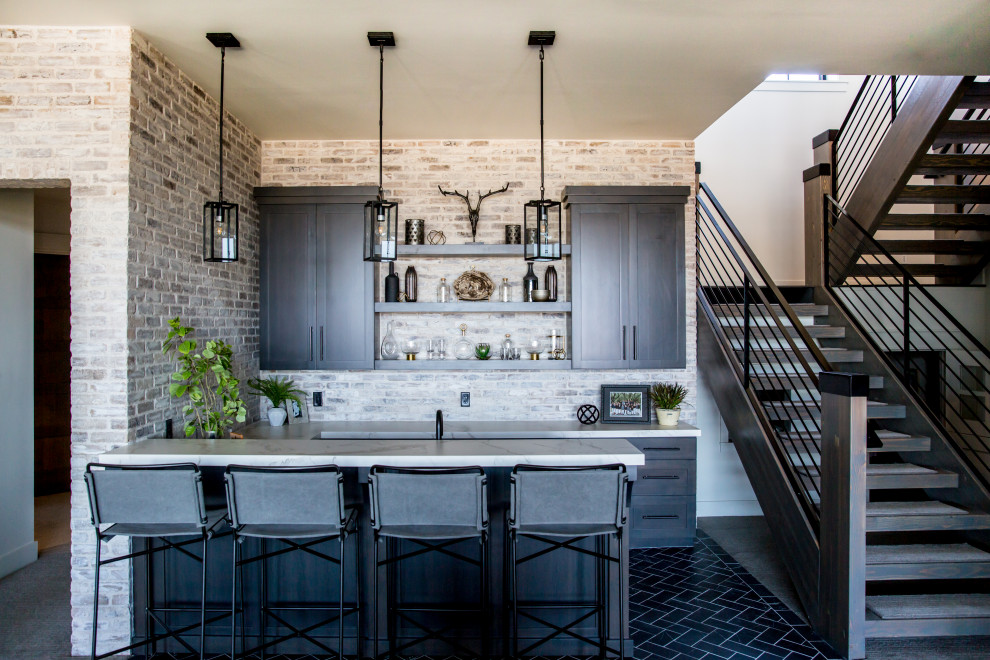 This is an example of a large country seated home bar in Salt Lake City with an undermount sink, dark wood cabinets, brick splashback and blue floor.