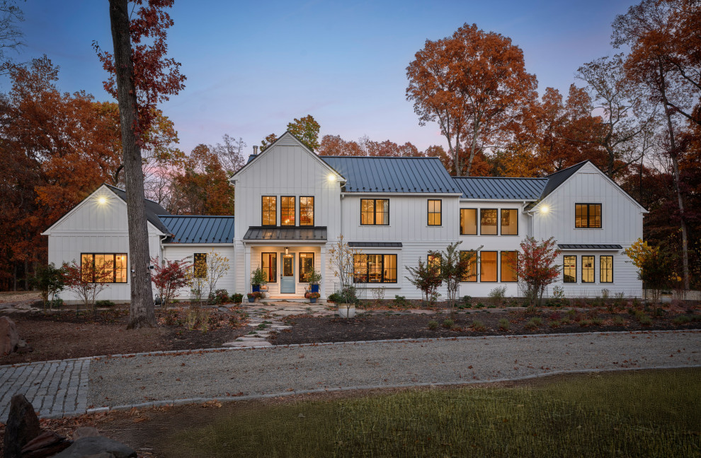 Country white two-story board and batten and clapboard exterior home photo in Philadelphia with a metal roof and a black roof