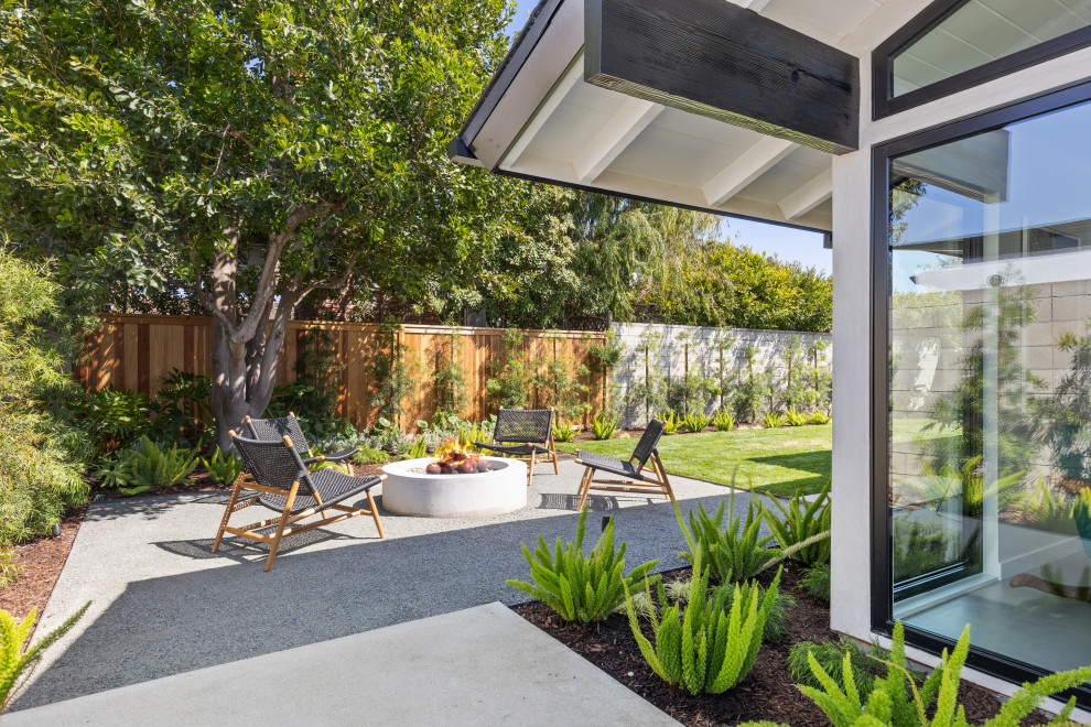 Ispirazione per un patio o portico minimalista con un focolare, ghiaia e nessuna copertura