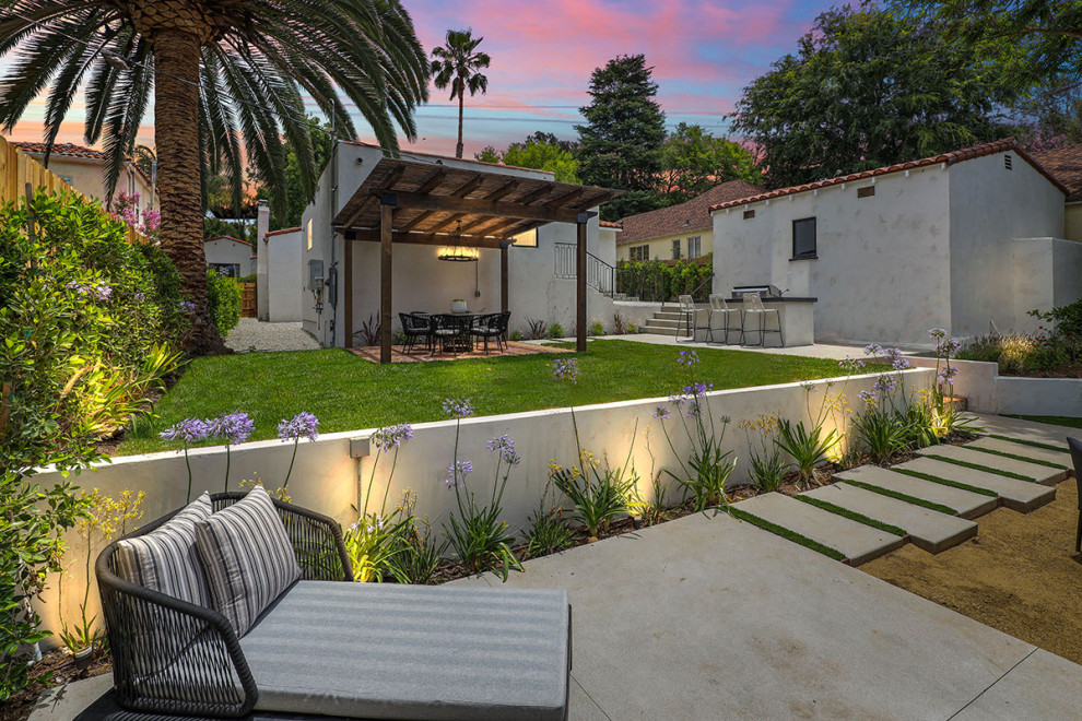 Design ideas for a mid-sized transitional backyard garden in Los Angeles with concrete pavers and a wood fence.
