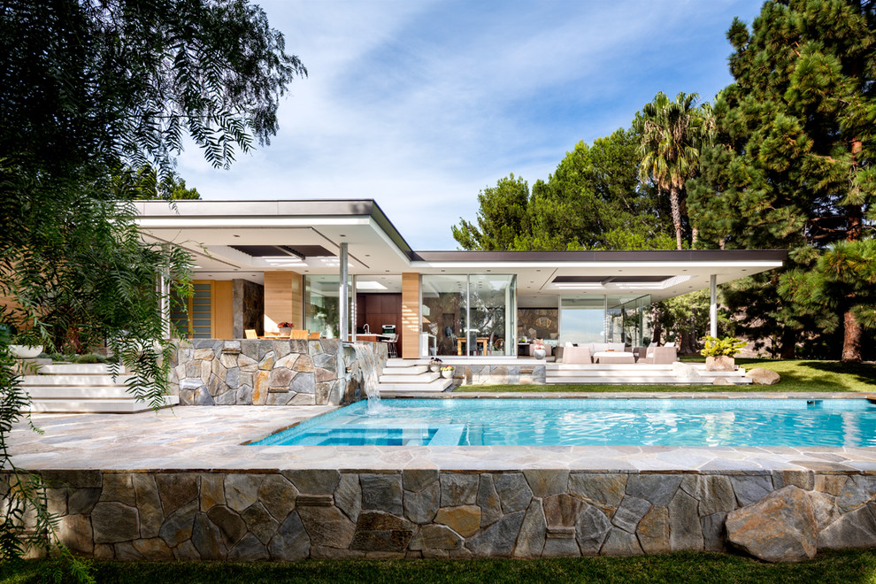 Inspiration for a large midcentury one-storey glass multi-coloured house exterior in Los Angeles with a flat roof.