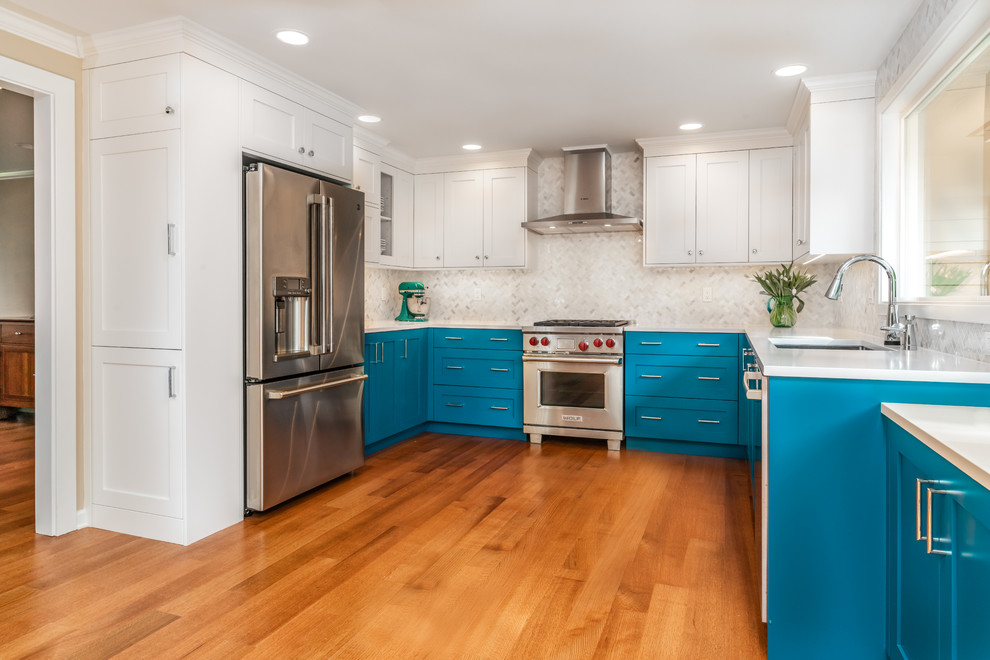Example of a small transitional u-shaped light wood floor kitchen pantry design in Seattle with an undermount sink, shaker cabinets, blue cabinets, quartz countertops, white backsplash, marble backsplash, stainless steel appliances and white countertops