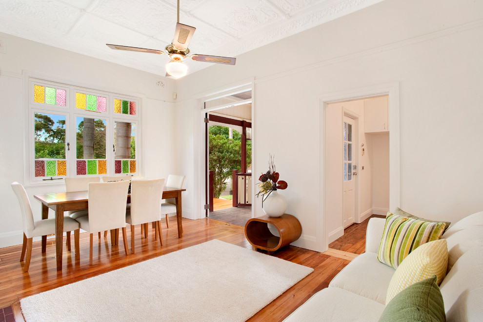 Inspiration for a transitional dining room in Sydney with white walls and medium hardwood floors.