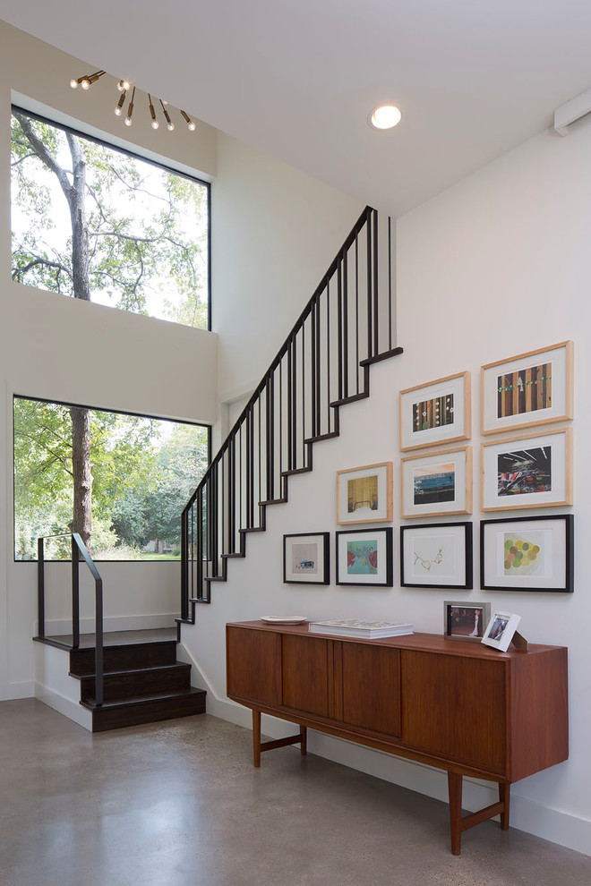 Photo of a small contemporary entryway in Austin with white walls and concrete floors.